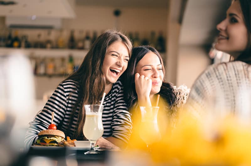 Young girls laughing over lunch